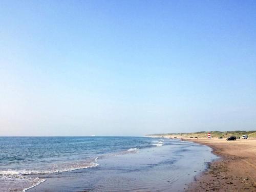 a beach with a group of people and the ocean at Luxury Seaside Retreat in Tornby-By Traum in Hirtshals
