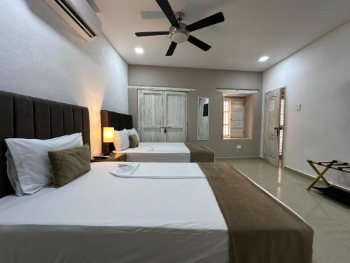 a bedroom with two beds and a ceiling fan at Hotel La Magdalena in Cartagena de Indias
