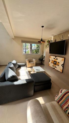 a living room with a couch and a tv at Casa moderna en Valeria del Mar in Valeria del Mar