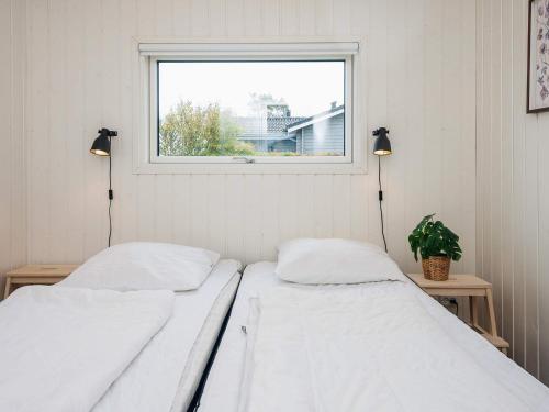 two beds in a room with a window at 6 person holiday home in Rønde-By Traum in Rønde