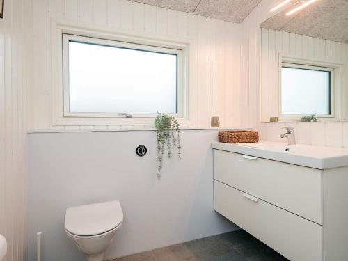 a bathroom with a toilet and a sink and a window at 6 person holiday home in Rønde-By Traum in Rønde