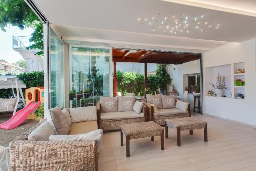 a living room with couches and chairs and a slide at B&B Airone Cervia - Camere e Appartamenti in Cervia