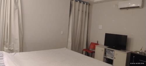 a bedroom with a bed and a flat screen tv at Pousada horbis in Guarabira