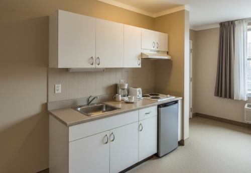 een keuken met witte kasten en een spoelbak bij Sevcan Apart 