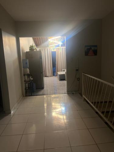 Una habitación vacía con un pasillo con suelo de baldosas. en Hostel Franca, en Montes Claros