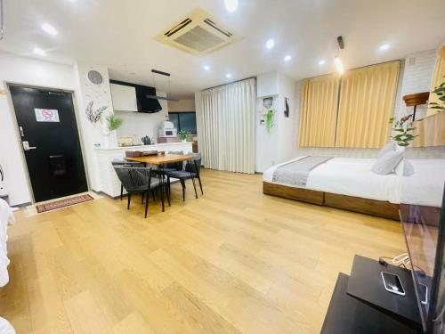a bedroom with a bed and a table and a kitchen at 東田端2F-kKI0064 in Tokyo