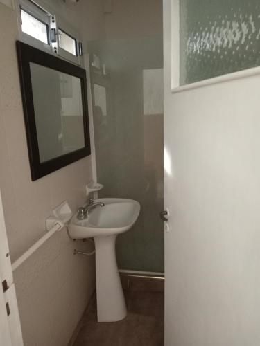 a white bathroom with a sink and a mirror at Casa con pileta,quincho ymas servicios para vos in Santa Teresita
