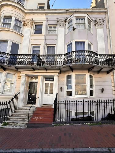 a white building with a staircase in front of it at Sachi Hotel in Brighton & Hove