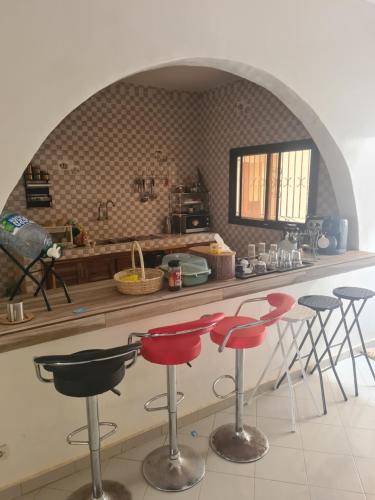 a kitchen with a counter with red stools in it at Villa NINA in Yof