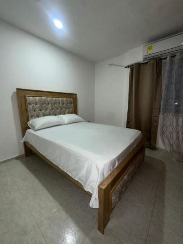 a bedroom with a large bed with white sheets at Grande y Hermoso apartamento urbano in Montería
