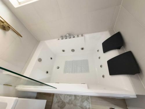 La salle de bains blanche est pourvue d'une douche avec des accessoires noirs. dans l'établissement Caribbean Cove of Deerfield Beach South Florida, à Deerfield Beach