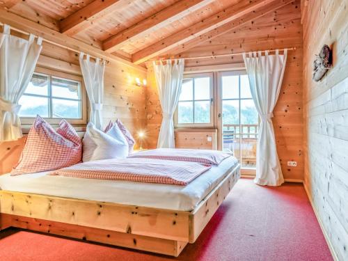 - une chambre avec un lit dans une maison en bois dans l'établissement Idylle am Waldrand, à Brixen im Thale