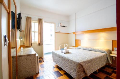 a hotel room with a bed and a window at Oscar Hotel in Florianópolis