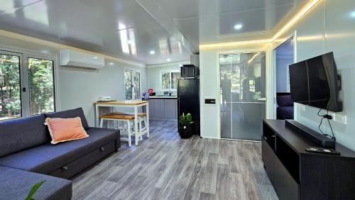 Una sala de estar con un sofá y un televisor de pantalla plana. en Live like a Farmer - Private Farm Stay Experience, en Tuggerah