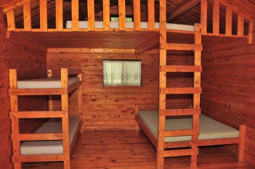 FremontにあるFremont RV Campground Loft Cabin 1の木造キャビン内のベッドルーム1室(二段ベッド2組付)