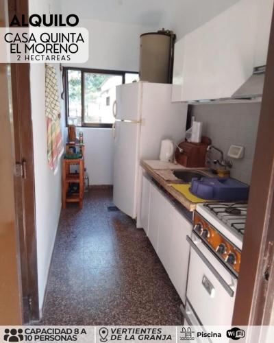 a kitchen with a white refrigerator and a sink at El morenito in La Granja