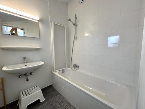 Un baño blanco con lavabo y bañera. en Westhinder II H19, en Witte Burg