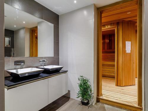 a bathroom with two sinks on a counter with a wooden door at 5 Bed in Polruan 77657 in Polruan