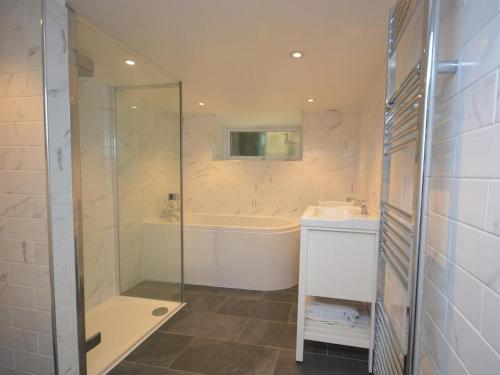 a bathroom with a shower and a tub and a sink at 3 Bed in Polruan PC012 in Polruan