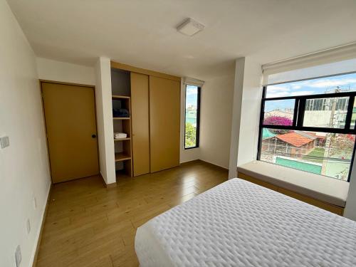 a bedroom with a bed and a large window at Depamor in Morelia
