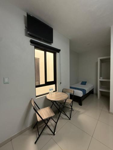 ein kleines Zimmer mit einem Tisch und einem Bett in der Unterkunft Hotel Santa Teresa in Tequila