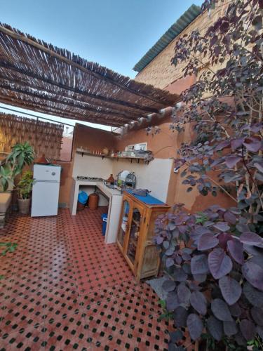 an outdoor kitchen with a counter and a refrigerator at Medina Oasis Hostel in Marrakesh