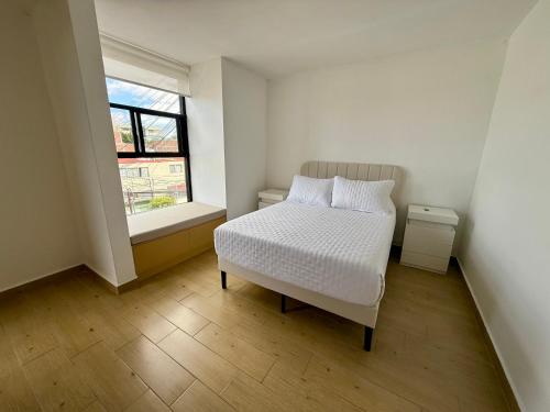 a small bedroom with a bed and a window at Depamor in Morelia