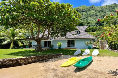 a house with three surfboards in front of a house at Villa Ohana - 4BR Beachfront Villa in Paopao