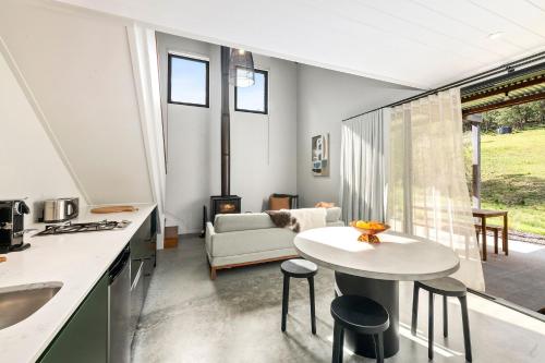 a kitchen and living room with a table and chairs at Nido, Kangaroo Valley in Upper Kangaroo River