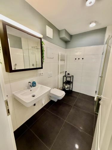 a bathroom with a white sink and a toilet at Helle Ferienwohnung in Leipzig! No3 in Leipzig