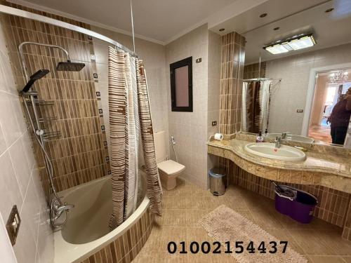 un bagno con vasca, lavandino e specchio di شقه عائليه 401سوبر لوكس في وسط الحي الافرنجي في مركز المدينه a Port Said