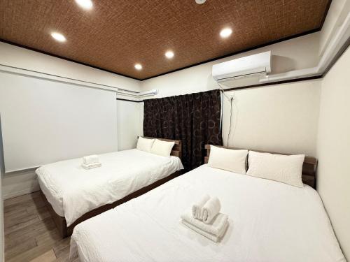 two beds in a room with white sheets and towels at Y-Shinjuku City, Okubo 5F-SJ0070 in Tokyo