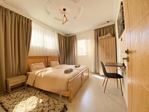 a bedroom with a bed and a table and a chair at Endless Wave Morocco in Agadir