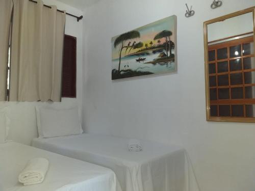 a white room with a bed and a window at Flat do Golfinho in Tamandaré