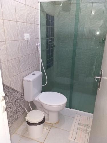 a bathroom with a toilet and a glass shower at Flat do Golfinho in Tamandaré