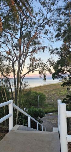 a view of the beach from the porch of a house at Spacious - Sunrise over the sea in Urangan