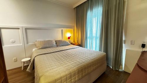 a bedroom with a large bed and a window at HOTEL PERDIZES - FLAT Executivo - 1402 in Sao Paulo