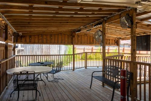 a wooden deck with a table and chairs on it at Budget Inn & Suites Baton Rouge in Baton Rouge