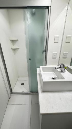 a white bathroom with a sink and a shower at Hotel em Perdizes - FLAT1402 - By TorresGuest in São Paulo