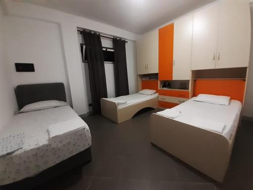 two beds in a room with orange and white at Villas for rent Elena feeling home in Durrës