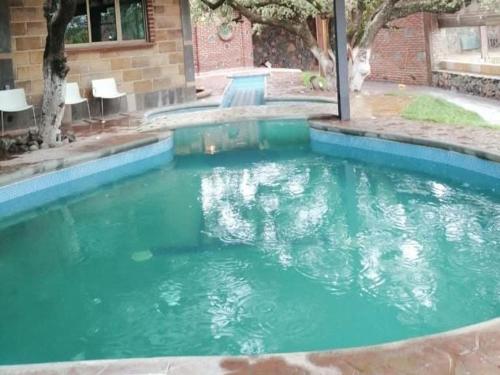a pool of green water in front of a building at luz y vida 