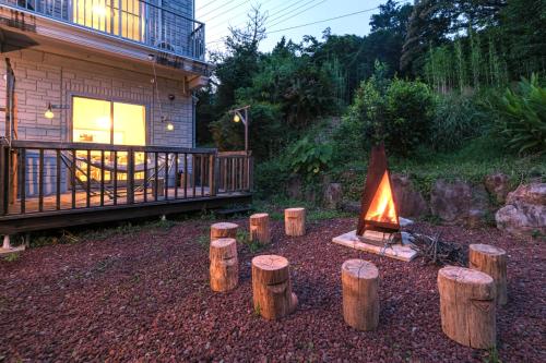 a fire pit in a yard next to a house at 愛犬と暮らすように過ごせる一棟貸しヴィラ イヌサウナリゾート伊豆白浜 in Shimoda