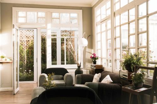 a living room with two couches and windows at Hostal Boutique Puerta Roja in Punta Arenas