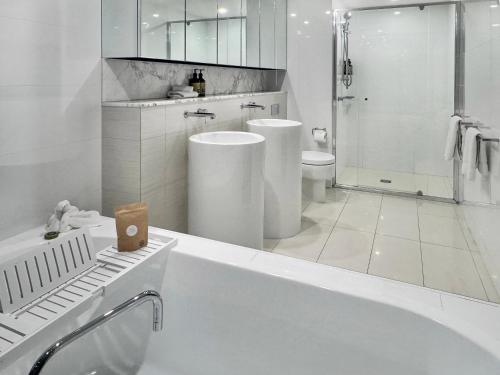 a white bathroom with a tub and a toilet at Oceanview Luxury Escape Oracle Tower 2 Level 24 in Gold Coast