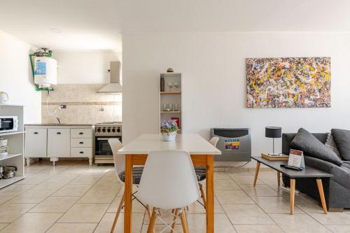 Una cocina y una sala de estar con una mesa y un sofá. en Tu Casa en San Rafael Centro y Confort, en San Rafael
