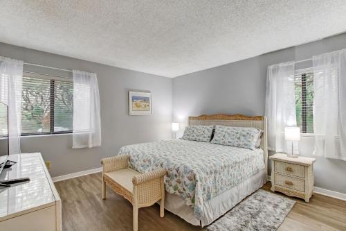 a bedroom with a bed and a desk and two windows at Recently updated 2 bedroom Beachwood Condo 2016 in Franklintown