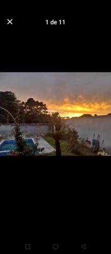 a picture of a sunset with a plane in the sky at Por do sol piscina e skate e churrasco in Piraquara