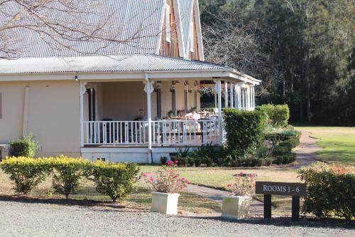 a house with people sitting on the porch at The Carriages Boutique Hotel and Vineyard in Pokolbin