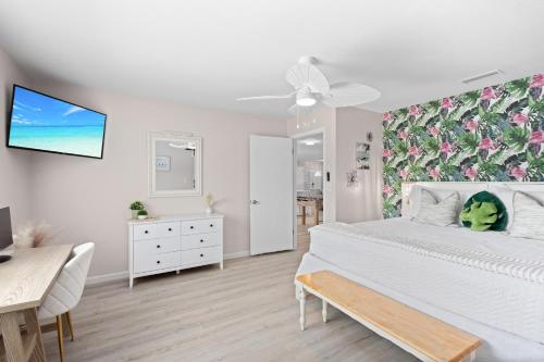 a bedroom with a white bed with a floral accent wall at Heated Pool, 75"tv, Hot Tub, 3 Kings, Ami & Img in Bradenton