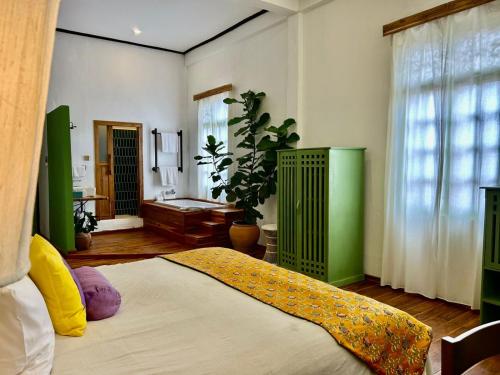 a bedroom with a bed and a large window at The Apsara in Luang Prabang